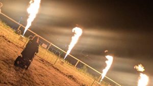 A picture of me, in my wheelchair, next to some flamethrowers.